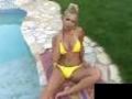 Blonde trop yes au bord de la piscine se caresse au soleil